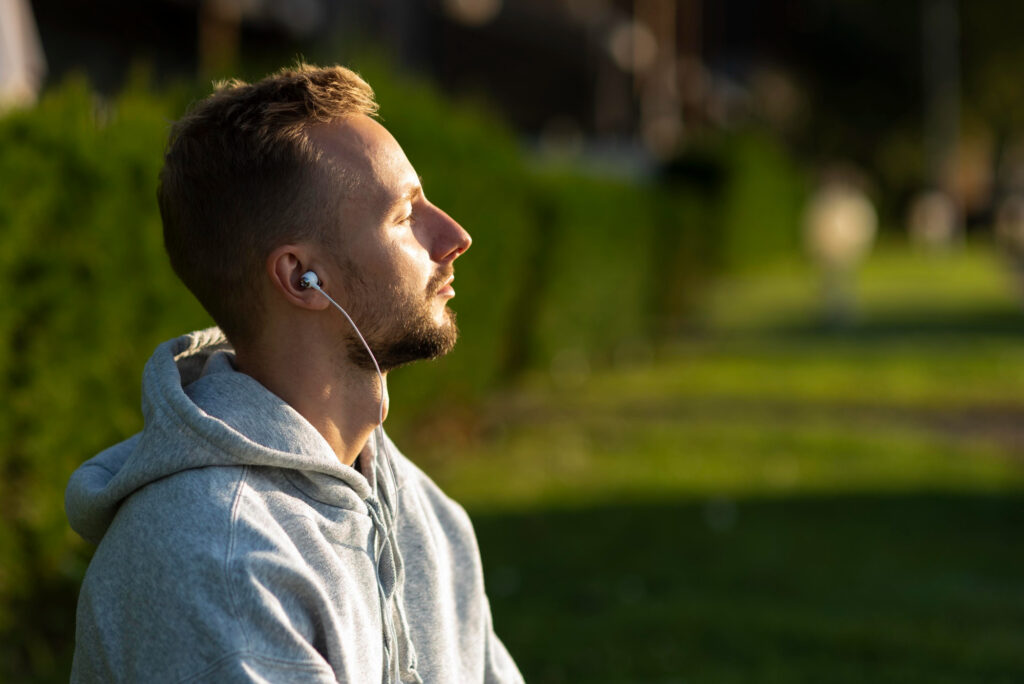 side view of man listening to music & meditating image by freepik