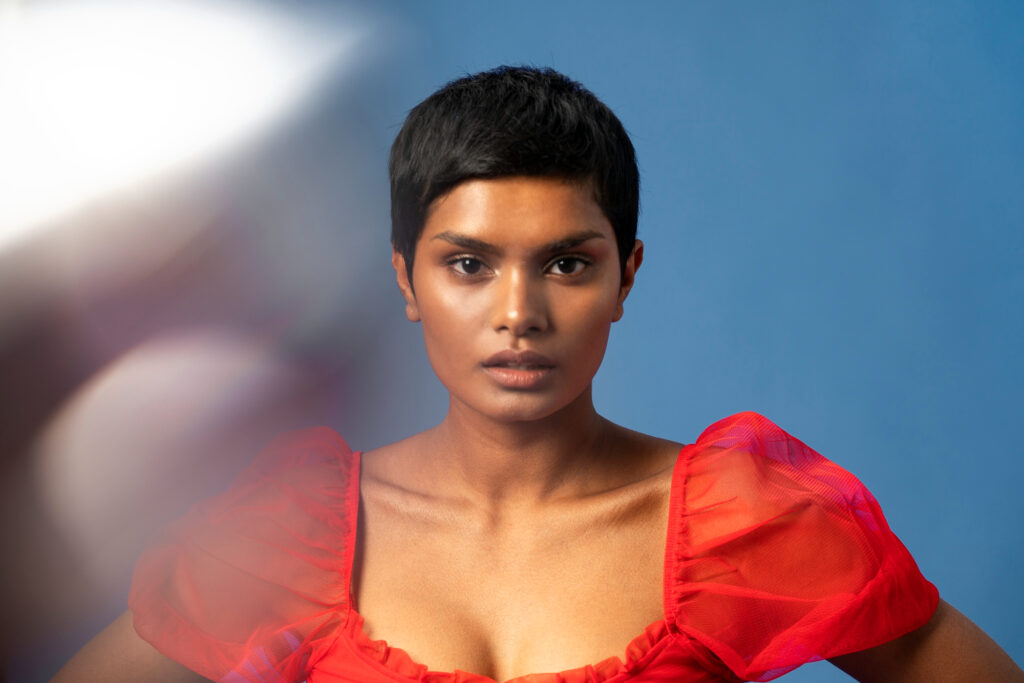 woman with short hair in red dress facing forward image by freepik