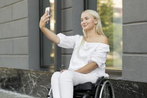 Woman in wheelchair taking selfie Image by Freepik