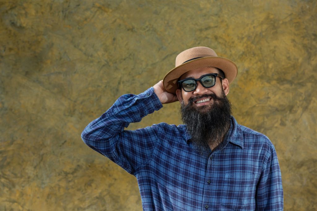 Young asian man with long beard and glasses wearing hat and glasses Image by jcomp on freepik