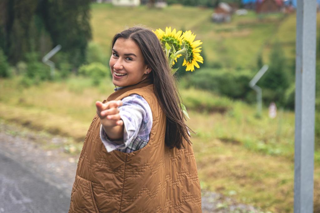 young woman walking in mountains with bouquet of sunflowers Image by pvproductions on freepik