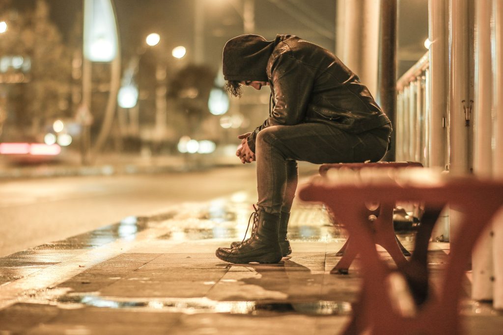 sad man in jacket sitting on sidewalk Image by Yakup Polat on pexels
